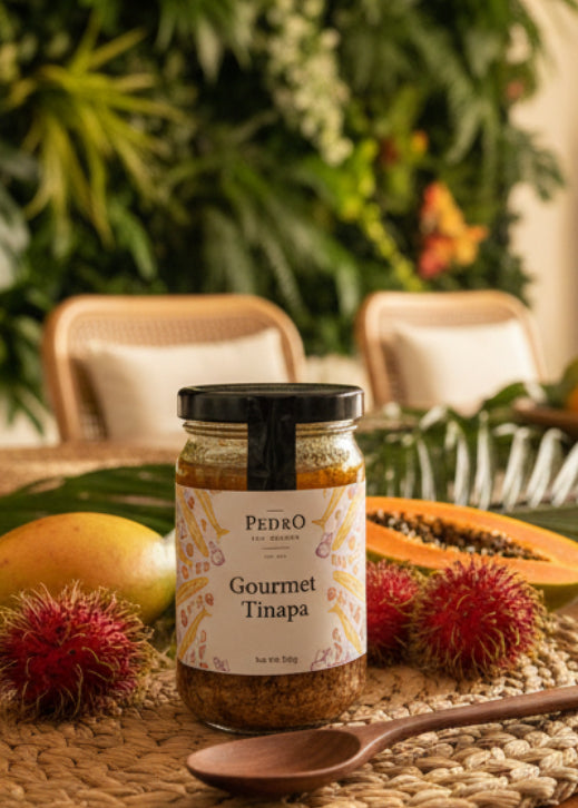 A glass jar of Pedro The Gourmet Gourmet Tinapa, featuring a white label with colorful illustrations and a black lid, set against a plain white background.