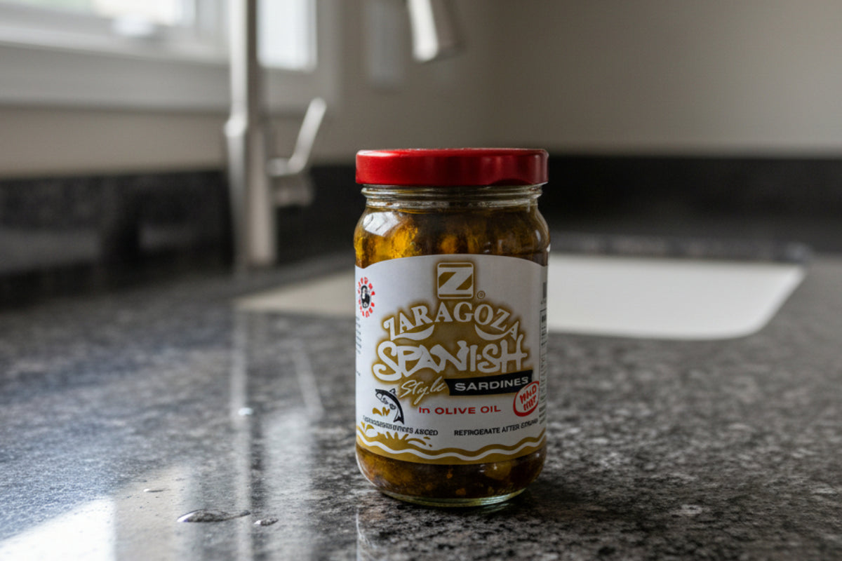 A glass jar of Zaragoza Spanish Style Sardines in Olive Oil with a red lid and white label, set against a plain white background.